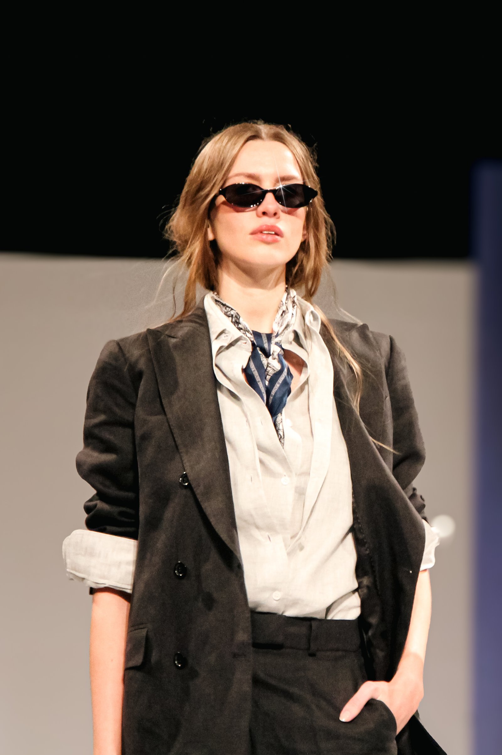 Modelo con anteojos de sol, blazer y pañuelo estampado